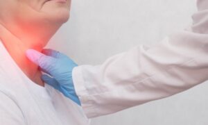 lekarz bada czy pacjentka ma guzki na tarczycy