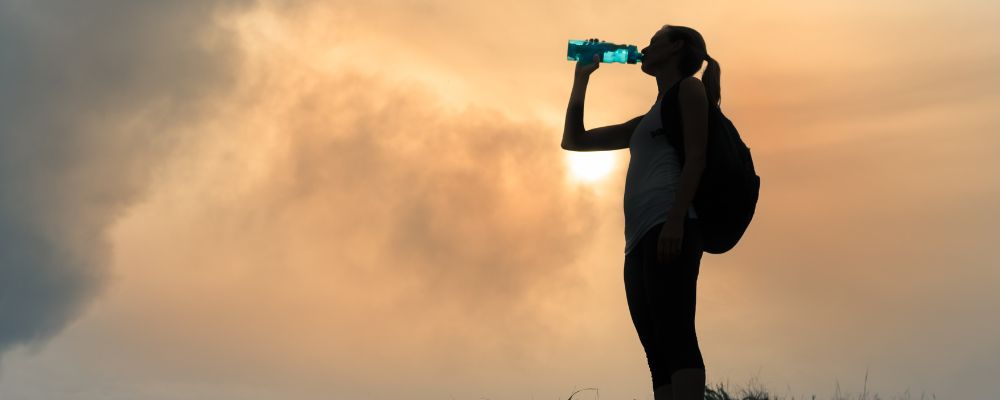 kobieta pije wode, grafika wiodąc do artykułu ile wody dziennie należy pić